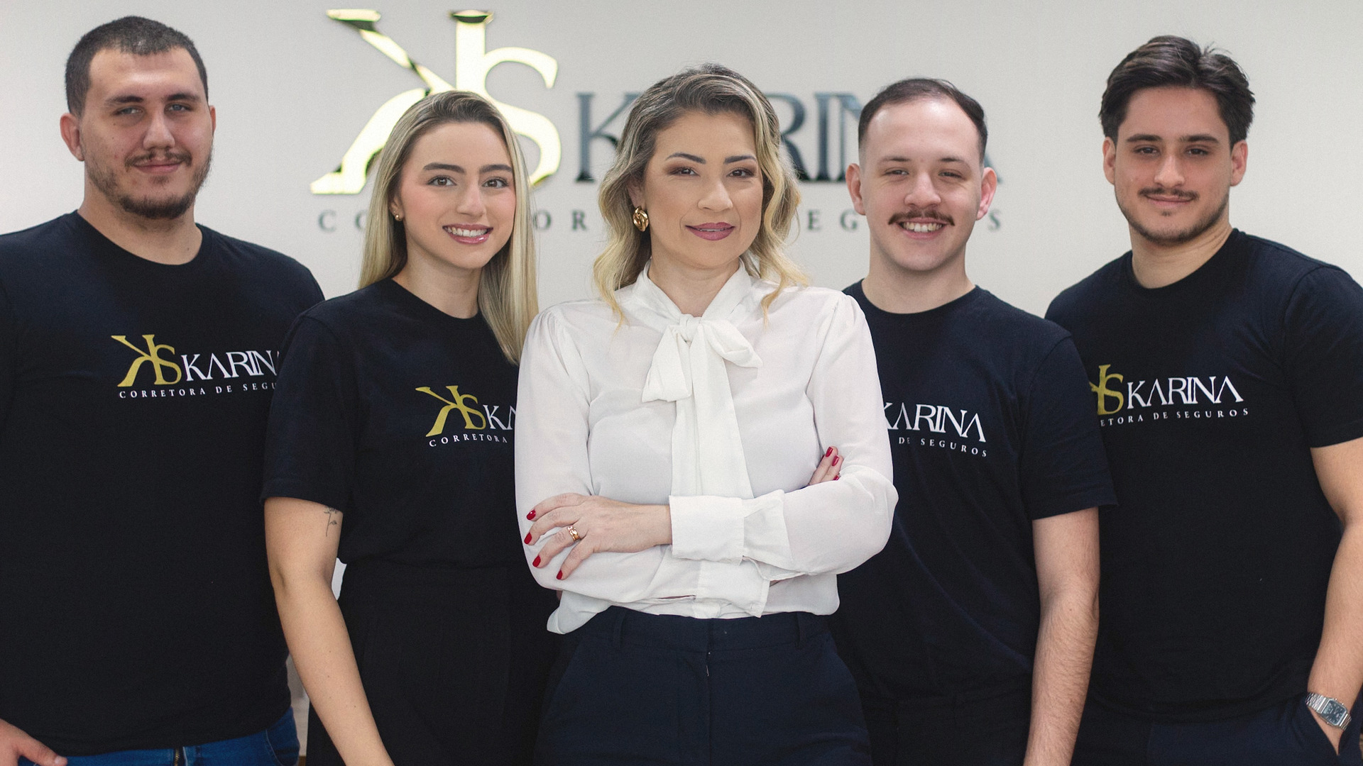 A equipe da Karina Corretora de Seguros no escritório, com Karina Silva Dezideiro ao centro